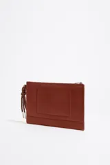 Neceser negro de piel con estructura blanda, asa de mano de cordón extraíble, logo metálico, acabados metálicos plateados, bolsillo interior y cierre con cremallera. Interior con etiqueta de tejido BIMBA Y LOLA.