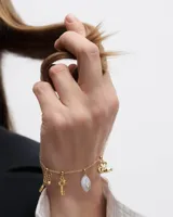 Aros colgantes con forma de cerezas doradas, con un pequeño cristal incrustado en una de ellas.