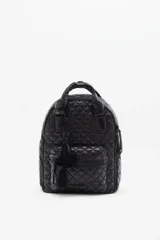 Mochila negra matelassé con correa ajustable y manijas para llevar al hombro. Tiene cierre de cremallera, accesorio colgante decorativo, bolsillo interno y espacio para laptop.