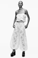 Pantalón bombacho de encaje color crudo, tiro alto, cintura elástica y forro interior.