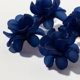 Aros colgantes con forma de flor en color azul marino.