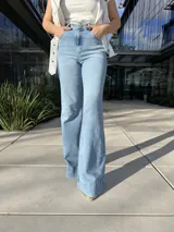 Pantalón de jean celeste de corte acampanado, tiro alto y bolsillos delanteros y traseros.