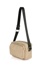 Bandolera color beige con correa larga negra ajustable. Tiene dos compartimentos con cierre y un bolsillo frontal con cierre.
