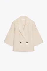 Blazer color crema de corte recto, con cuello solapa, manga francesa y cierre cruzado con dos botones negros.