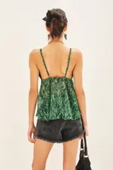 Top bretelero con estampado reptil en tonos verdes, confeccionado en gasa con lurex y forrería a tono en tazas. Posee elástico en la parte de la espalda.
