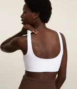 Top deportivo blanco de poliamida, sin copa, sin estampa y con escote redondo.