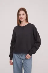 Sudadera holgada color gris oscuro, con manga larga y cuello redondo.