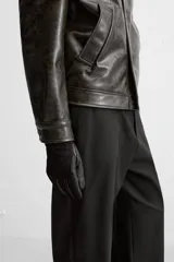 Pantalón negro de corte recto con cintura elástica, bolsillos delanteros y traseros. Cierre frontal con cremallera y botón.