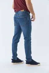 Pantalón de jean gris oscuro, corte carrot, tiro medio, con logo bordado y presillas para cinturón.