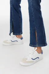 Zapatillas urbanas blancas con detalles en azul y beige.