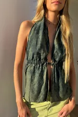 Top halter confeccionado en jean fino color verde con efecto lavado. Presenta espalda abierta y ajuste con lazos.