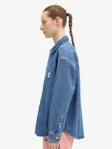 Camisa de denim azul de Carhartt WIP, de corte holgado, manga larga, cuello clásico y cierre frontal con botones. Tiene un bolsillo en el pecho con etiqueta con el logo de la marca.