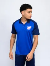 Remera polo de poliéster con mangas cortas y cuello clásico en contraste. Presenta el escudo del Club Nacional de Football en el pecho.