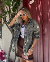 Camisa de denim con lavado ácido (acid wash) en tonos grises y azules, de corte holgado y botones dorados.