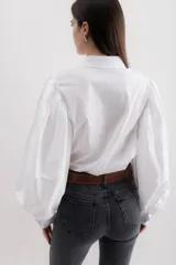 Camisa color beige de algodón con mangas abullonadas y cierre con botones.