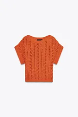 Top corto de punto color naranja, con cuello redondo amplio y manga corta.