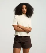 Remera blanca de algodón con cuello alto en punto roma y mangas cortas. Corte amplio y diseño básico.