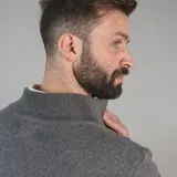 Campera tejida azul marino con cierre frontal, cuello alto y bolsillos laterales.