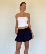 Pollera corta azul marino con finas rayas blancas verticales, cintura elastizada con cordón ajustable y ruedo con terminación festoneada.