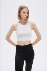 Top blanco sin mangas de poliéster, de punto canalé, al cuerpo y con cuello a la base.