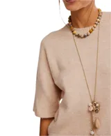 Sweater tipo tee color beige, de estilo oversized y mangas cortas.