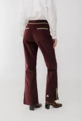 Pantalón de pana marrón con corte acampanado y abertura en el ruedo.
