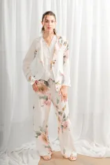 Blazer de lino blanco con estampado floral en tonos rosa y verde, corte holgado, cuello solapa y bolsillos laterales.