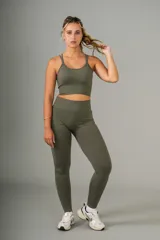 Conjunto deportivo color verde oliva, compuesto por un top corto con tirantes finos y calzas largas de cintura alta.