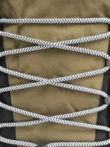 Mochila gris claro y gris oscuro con cordones elásticos cruzados en el frente y logo de la marca en la parte superior.