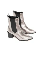 Bota corta plateada con textura de cuero metalizado, elásticos laterales negros y tacón cuadrado.