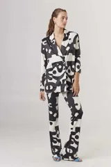 Blazer con estampado abstracto en blanco y negro, con solapas de muesca, cierre con dos botones y corte recto.