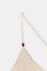 Mono color crema de tirantes finos cruzados en la espalda, escote redondo y corte holgado con puños elásticos en los tobillos.