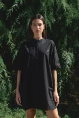 Camisa negra de algodón con cuello mao y mangas cortas. Presenta un pequeño bordado de una flor blanca en el pecho.