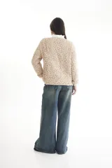 Sweater de punto calado color crema, con cuello alto y mangas largas.