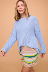 Sweater tejido en algodón color celeste, de corte holgado, mangas largas anchas y cuello bote.