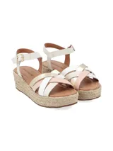 Sandalias de plataforma con suela de yute, tiras cruzadas de cuero negro y plateado, y pulsera al tobillo con hebilla metálica.
