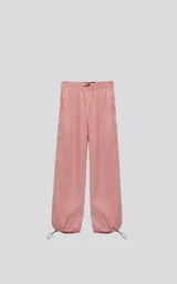 Pantalón de corte sastrero color salmón, de tela suede suave y holgada, con bolsillos laterales, cintura trasera elástica ajustable y cierre frontal con botón.