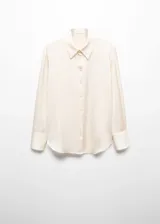 Camisa color crema de tejido fluido con textura y acabado satinado. Diseño recto, cuello clásico, manga larga con puños abotonados y cierre frontal con botones.