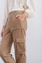 Pantalón de corderoy gris, de corte holgado, con elástico en la cintura, cierre y botón. Tiene bolsillos aplicados en el delantero y puños con elástico interno.