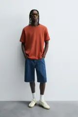 Remera color arena de corte recto, cuello redondo y mangas cortas.