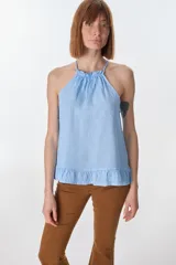 Musculosa color beige de lino, con cuello halter con volados y volados en el ruedo.