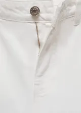 Short blanco de tiro bajo, corte holgado y largo a la rodilla, con cierre de cremallera y botón, trabillas, dos bolsillos delanteros de parche, bolsillo monedero, bajo deshilachado y dos bolsillos traseros de parche.