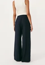 Pantalón de lino color crema, de corte recto y tiro alto, con cintura elástica ajustable con cordón y bolsillos laterales.