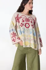 Sweater color crudo con bordado de flores rojas, amarillas y azules.