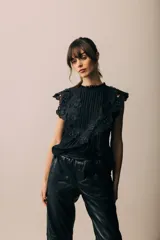 Blusa negra sin mangas con cuello redondo, detalle de volados de encaje con apliques y pinzas verticales en el frente.