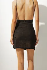 Minifalda marrón con rayas verticales negras y blancas, de corte cruzado con lazo lateral.