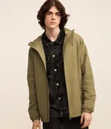 Campera rompevientos color verde oliva, con capucha ajustable con cordón, cierre frontal con cremallera, bolsillos laterales con cremallera y puños elásticos.