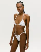 Conjunto de bikini blanco con estampado de lunares negros. El corpiño es de triángulo con tirantes finos y la bombacha es colaless. Confeccionado en lycra UV.
