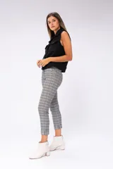 Chaleco negro de tejido boucle con cuello solapa, cierre frontal con botones metálicos, dos bolsillos de parche con botón en el pecho y corte recto.