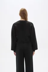 Buzo color marrón con cuello redondo y mangas largas abullonadas.